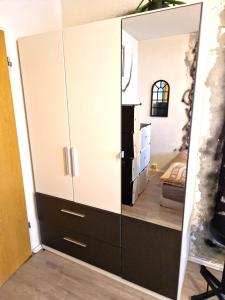 a large cabinet with a mirror in a room at Cozy trendy spacious room in green area 12 min. near to the center Alexanderplatz in Berlin