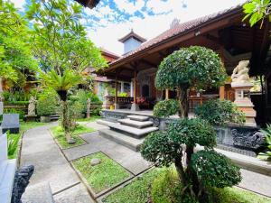 a house with a garden with trees and stairs at Aura Bisma Guesthouse in Ubud