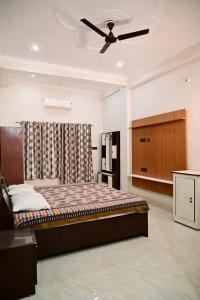 een slaapkamer met een bed en een plafondventilator bij Surendra Villa in Ayodhya