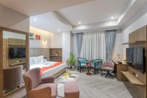ein Hotelzimmer mit einem Bett, einem Tisch und Stühlen in der Unterkunft De Crown Inn in Jogīkuti