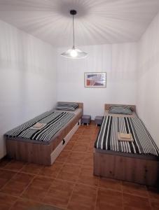 2 Einzelbetten in einem Zimmer mit einer Decke in der Unterkunft Studio Central Square in Gospić
