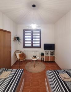 ein Zimmer mit zwei Betten und einem Tisch und einem Fernseher in der Unterkunft Studio Central Square in Gospić