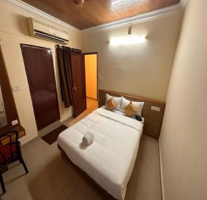 a bedroom with a white bed in a room at Citi Business Hotel in Pondicherry