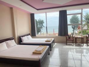 Habitación de hotel con 2 camas y ventana grande. en Hải Yến Hotel Quảng Bình, en Dong Hoi