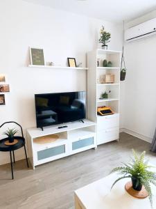 a living room with a white entertainment center with a flat screen tv at Céntrico piso con parking disponible by beBalmy in Málaga