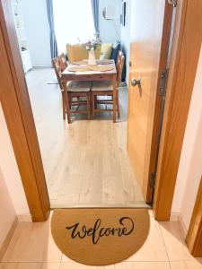 a welcome mat in front of a door with a dining room at Céntrico piso con parking disponible by beBalmy in Málaga
