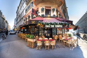 a restaurant with tables and chairs on a city street at Lumineux. Studio République/Bastille, Marais in Paris