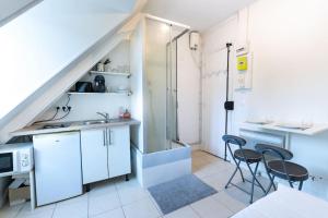 a kitchen with a sink and two chairs in it at Lumineux. Studio République/Bastille, Marais in Paris