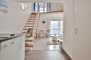 a kitchen and living room with a spiral staircase at Haus Miramar Treffert Appartement 21 in Niendorf