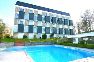 a building with a swimming pool in front of a building at Haus Miramar Treffert Appartement 21 in Niendorf