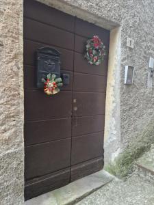 Una puerta de garaje negra con coronas. en Perla nelle Orobie, en Bema
