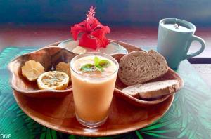 a plate of food with a drink and bread at L'Auberge de Tahiti Iti - Beach hostel in Afaahiti