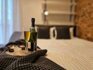 a table with a bottle of wine and two glasses at URABN APARTMENTS Studio with garden No 2A Chorzów Katowice FREE PRIVATE PARKING in Chorzów