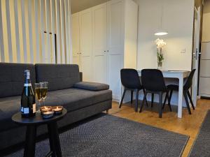 uma sala de estar com um sofá e uma mesa com uma garrafa de vinho em URBAN APARTMENTS STUDIO No 3A Chorzów Katowice, FREE PRIVATE PARKING em Chorzów