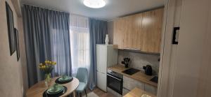 una pequeña cocina con mesa, fregadero y encimera en Lux Home Astana, en Öskemen