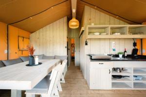a kitchen and dining room with a table and chairs at Glampingzelt Family - Lodge in Soltau