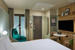 倫敦的住宿－master St. Paul's，酒店客房带一张床、椅子和电视