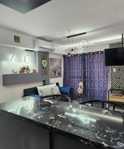 Condo Azur Suites B207 near Airport, Netflix, Stylish, Cozy with swimming pool في Lapu Lapu City: غرفة معيشة مع طاولة وأريكة