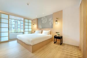 Un dormitorio con una gran cama blanca y una ventana en Salaya One Hotel & Service Apartment, en Salaya