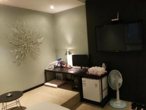 a room with a desk with a computer and a fan at Hi Design Hotel in Busan