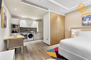 ein Schlafzimmer mit einem Bett und einem Schreibtisch sowie eine Küche in der Unterkunft Keysplease Modern Studio Near Beach, Murjan JBR 606 in Dubai