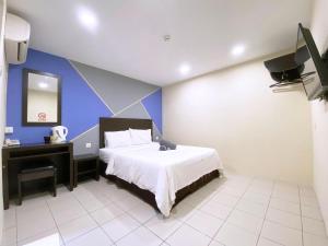 a bedroom with a bed and a tv in it at Your Hotel Klang in Klang