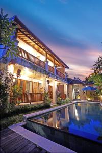 a house with a swimming pool in front of a house at Ari Cottages Ubud in Ubud
