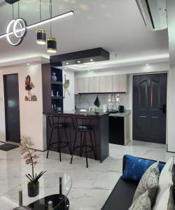 a kitchen and living room with a couch and a bar at Condo Azur Suites B207 near Airport, Netflix, Stylish, Cozy with swimming pool in Lapu Lapu City