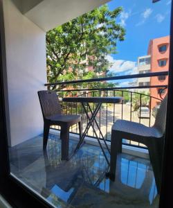 a balcony with two chairs and a table on a balcony at Condo Azur Suites B207 near Airport, Netflix, Stylish, Cozy with swimming pool in Lapu Lapu City