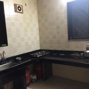 a kitchen with a black counter and a sink at Luxurious 2BHK villa with garden in Solapur