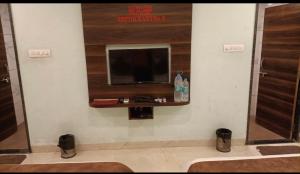 a bathroom with a flat screen tv on a wall at The royal galaxy & Resort in Bedla
