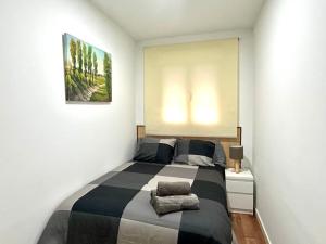 1 dormitorio con 1 cama y una pintura en la pared en Bustos Dreams, en Madrid