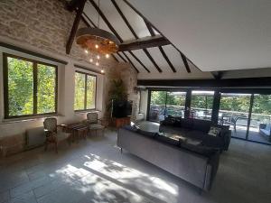 ein Wohnzimmer mit einem Sofa, einem TV und Fenstern in der Unterkunft Idyllic Private Island Watermill Paradise in Roquebrune