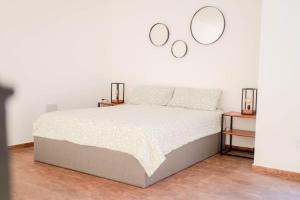 a bedroom with a bed with two mirrors on the wall at CasaVaras in Las Varas