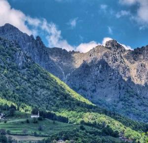 a green hillside with mountains in the background at Agriturismo Grabbia in Grumo