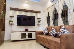 a living room with a couch and a flat screen tv at Williams Park Suite in Bangalore