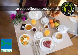 ロデーズにあるHÔTEL LA FERME DE BOURRAN - écoresponsable parking gratuitのテーブル(朝食用の食品、ドリンク付)