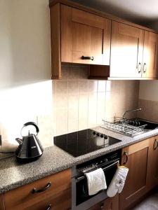a kitchen with wooden cabinets and a stove top oven at Beautiful holiday flat in Alnwick in Alnwick