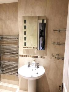 uma casa de banho com um lavatório e um espelho em Beautiful holiday flat in Alnwick em Alnwick