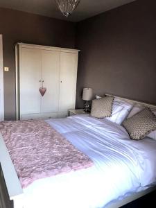 una camera da letto con un grande letto con una coperta rosa di Beautiful holiday flat in Alnwick ad Alnwick