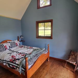 a bedroom with a bed and a window at Giyabwe Cottage in Macclesfield