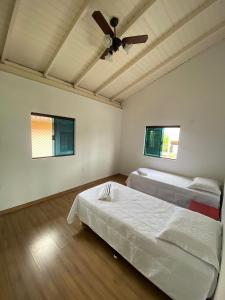 sypialnia z 2 łóżkami i wentylatorem sufitowym w obiekcie Yellow House casa no coração de Santo Antônio de Lisboa w mieście Florianópolis