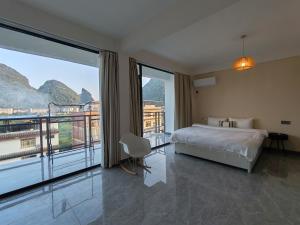 a bedroom with a bed and a large window at shadow climers guest house in Yangshuo +81 photos