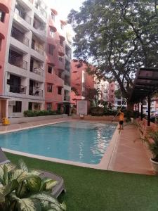 a person is cleaning a swimming pool in a building at Condo Azur Suites B207 near Airport, Netflix, Stylish, Cozy with swimming pool in Lapu Lapu City