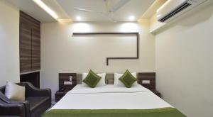 a bedroom with a bed and two chairs at Hotel Palliate in Ahmedabad