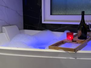 a bottle of wine and a candle in a bath tub at Välkomsthörnet in Stockholm