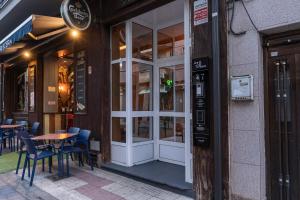 a door to a restaurant with tables and chairs outside at Hostal Julio Cesar in La Virgen del Camino