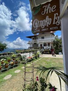 una señal frente a un edificio con plantas en The Gingko Eyrie , Kalimpong en Kalimpong