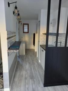 eine Küche mit weißen Wänden und einer schwarzen Tür in der Unterkunft Petite maison de charme à 1km du lac de Sanguinet et 20min d'Arcachon in Sanguinet