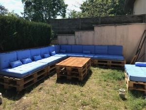 eine blaue Couch und ein Holztisch im Hof in der Unterkunft Petite maison de charme à 1km du lac de Sanguinet et 20min d'Arcachon in Sanguinet